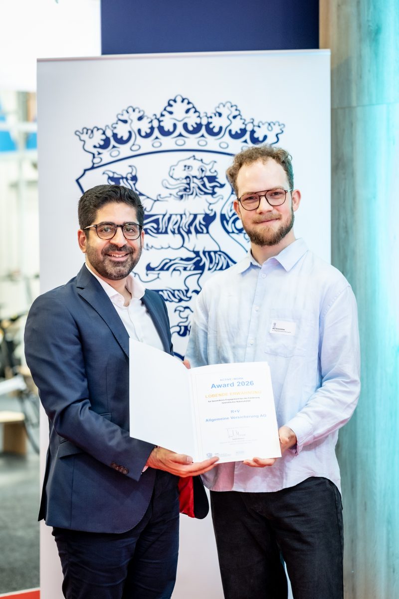 Wirtschafts- und Verkehrsminister Kaweh Mansoori überreicht Nils-Florian Höhler von der R+V Versicherung AG die Urkunde zur lobenden Erwähnung 